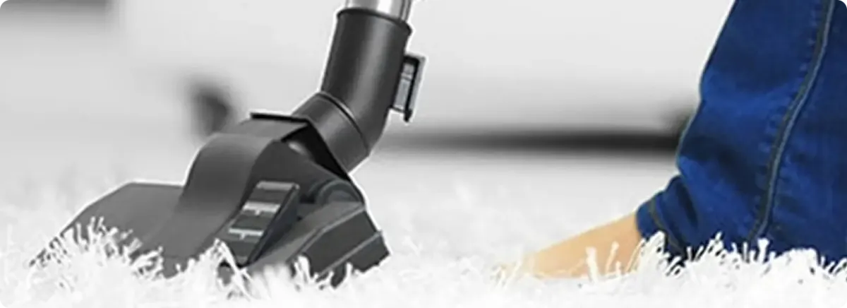 Close-up of a professional vacuuming a white carpet in Boca Raton.